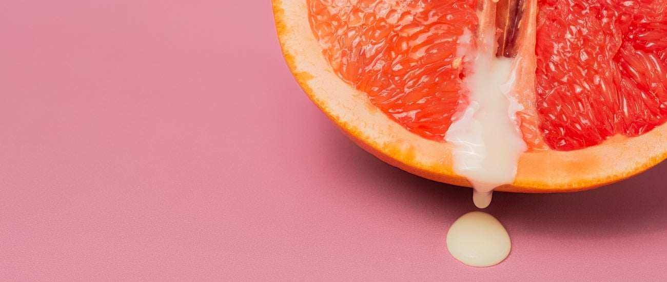 Grapefruit auf pinken Hintergrund mit weißer Flüssigkeit in der Mitte