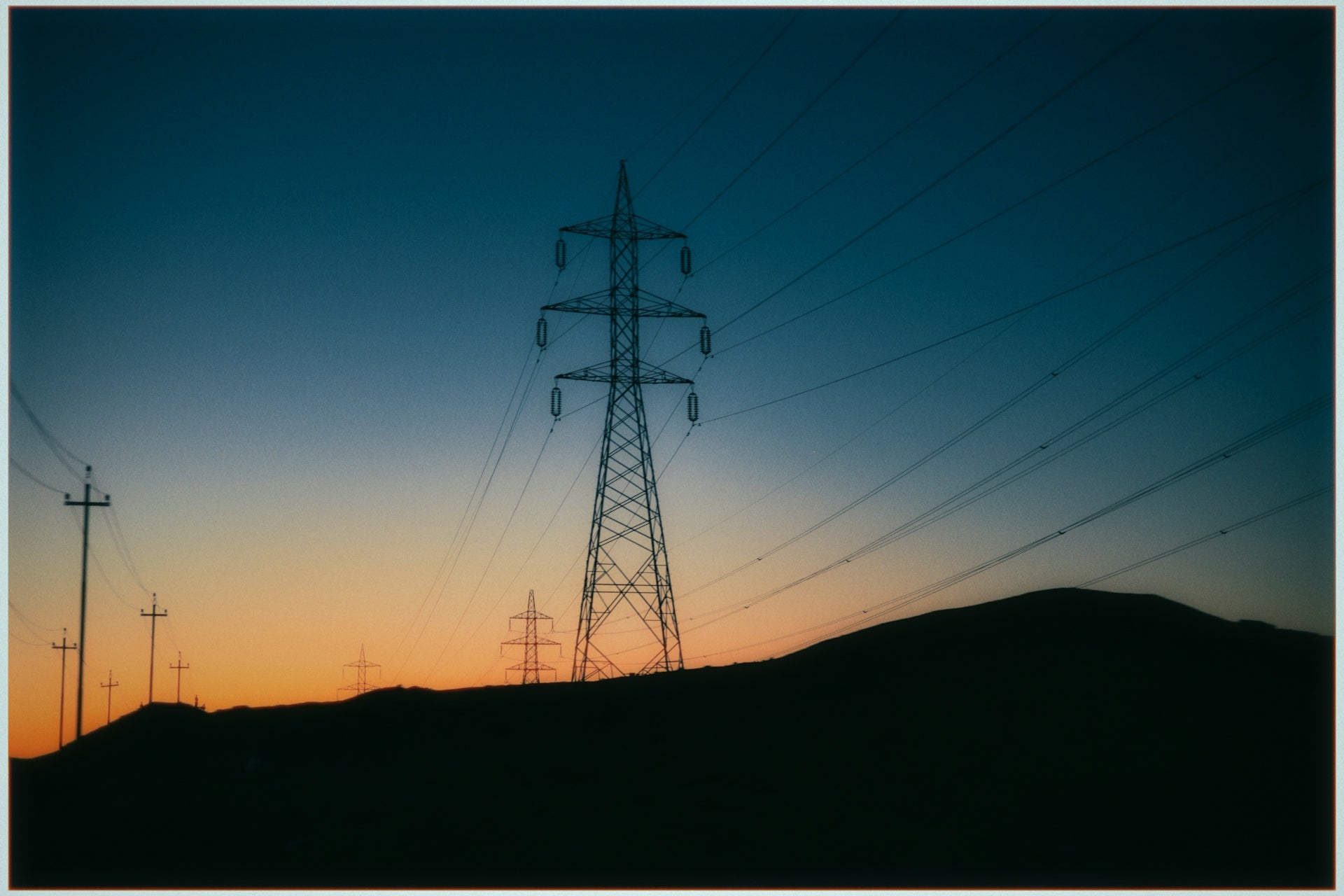 Power lines silhouetted against a twilight sky.
