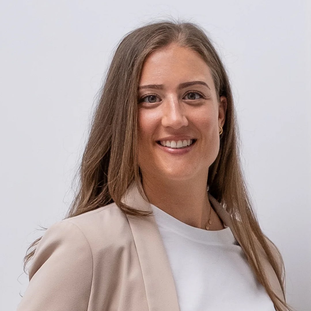 Eine brünette Frau mit weißem T-Shirt im Portrait Modus, lächelt in die Kamera