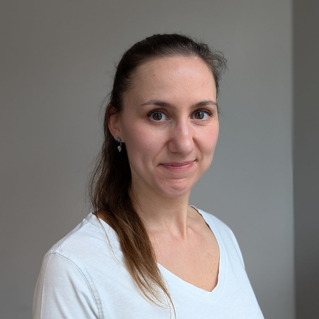 Eine dunkelhaarige Frau im Portraitmodus lächelt in die Kamera